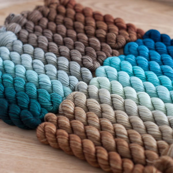 Set of yarn skeins in various colors on a wooden surface