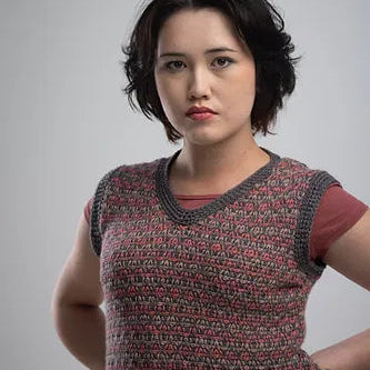 Woman wearing a patterned sleeveless top against a plain background